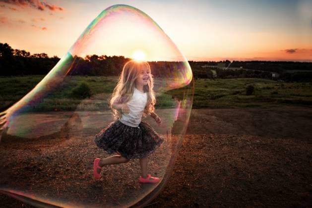 Creative Highlights Symbolbilder Happy little girl playing in giant colorful bubble outdoors Wooster, Ohio, United States CR_JOKU240507CB-1422592-01 ,model released, Symbolfoto