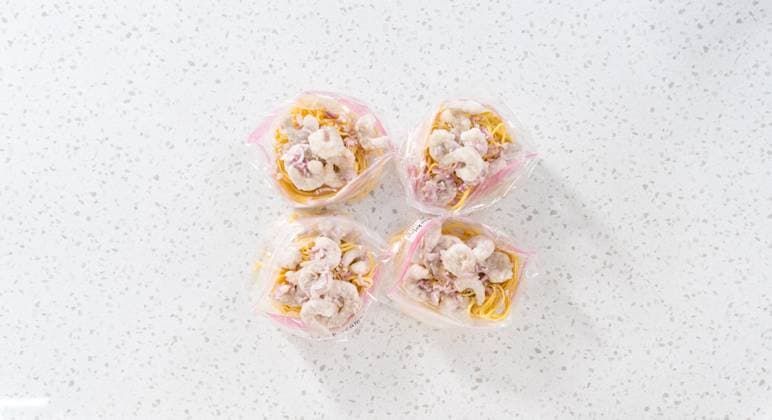 IMAGO Creative, Food, Trend, Meal Prep Frozen shrimp scampi meal prep Flat lay. Packaging homemade frozen shrimp scampi meal prep into plastic resealable bags. Copyright: xArinaxHabich RECORD DATE NOT STATED