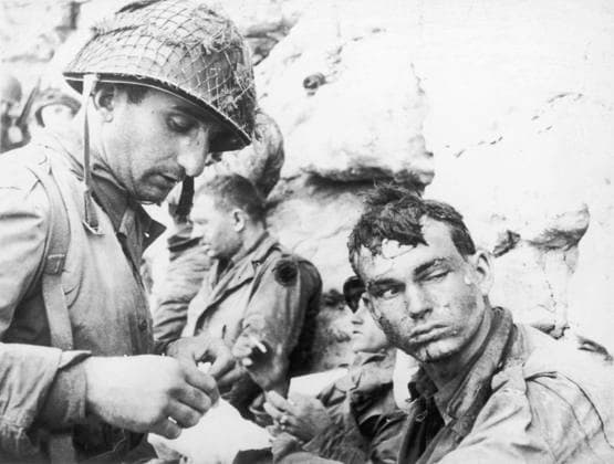 RECORD DATE NOT STATED D-Day - Injured American soldier An injured American soldier, his hair matted with blood , sweat and sand, has his hand bandaged by an American medical officer. D-Day began on June 6th, 1944 at 6:30am and was conducted in two assault phases  Copyright: Copyrightx(c)Geminix2023.xCredit:xGemini 10282384