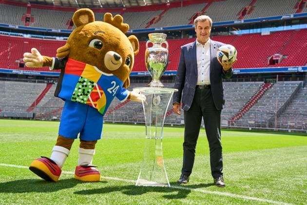 Ministerpräsident Dr. Markus Söder (CSU) auf dem Fußball Spielfeld der Allianz Arena in München. Er steht neben dem Henri-Delaunay-Pokal der UEFA EURO 2024 und hält einen originalen Adidas Fußball der Fußballeuropameisterschaft