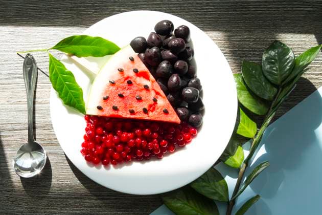 Summer snack. Fresh berries and fruits on a wooden table with green leaves of plants Summer snack. Fresh berries and fruits on a wooden table with green leaves of plants. Copyright: x RECORD DATE NOT STATED