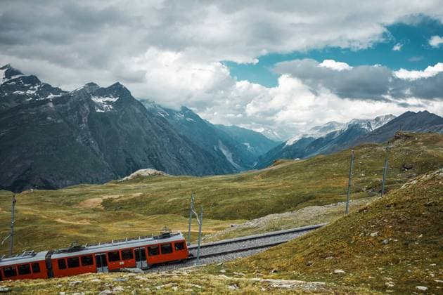 Railway and red train in Gornergrat mountains. Zermatt, Swiss Alps. Adventure in Switzerland. Railway and train in cloudy Gornergrat mountains. Zermatt, Swiss Alps. Adventure in Switzerland. High quality photo Copyright: x RECORD DATE NOT STATED