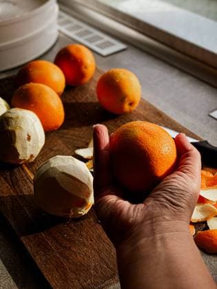 orange in hand for peeling Dnipro, Dnipropetrovsk Oblast, Ukraine R_PMDCMQ240514-1433469-01