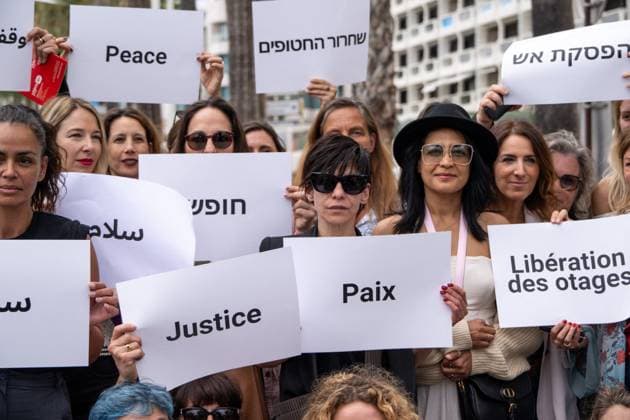 Cannes - Guerrieres De La Paix Flash Mob Action for Gaza and Israel Moroccan Belgian actress Loubna Azabal (first from L) and producer Lamia Chraibi (2nd from L) and other women from ?Women warriors of peace? carry messages in French, Arabic, Hebrew and English stating ?Peace?, ?Cease Fire?, Release the Hostages?, demonstrate on the ?Croisette? in Cannes, to draw attention to the situation in Gaza and Israel, around the 77th Cannes Film Festival, in Cannes, France, on May 20, 2024. Photo by Ammar Abd Rabbo ABACAPRESS.COM Cannes France Copyright: xABACAx