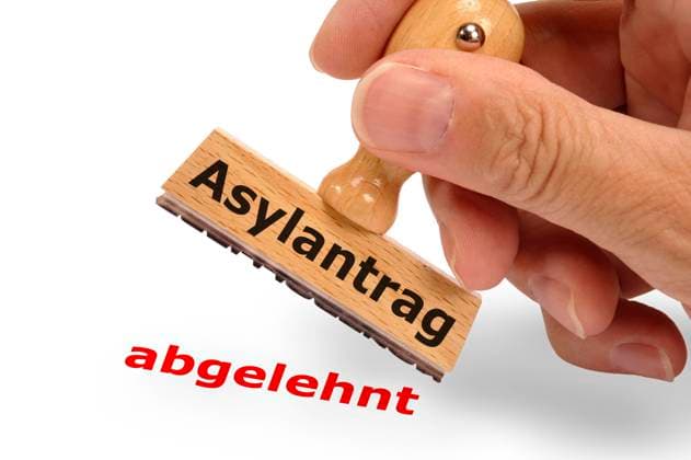 Asylantrag abgelehnt Ein Holzstempel in der Hand mit Aufschrift Asylantrag und dem Abdruck abgelehnt *** Asylum application rejected A wooden stamp in the hand with the inscription Asylum application and the imprint rejected