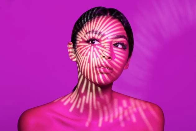 Creative Highlights Symbolbilder Beautiful young woman with light pattern on face against pink background model released, Symbolfoto, LMCF01179