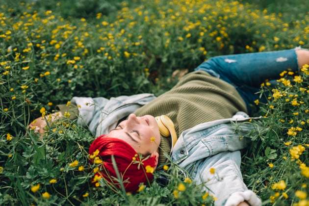 Creative Highlights Symbolbilder Smiling redhead woman lying on grass at park model released, Symbolfoto, OLRF00316