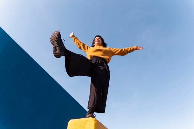 Creative Highlights Symbolbilder Carefree woman balancing on one leg under sky model released, Symbolfoto, PCLF01021