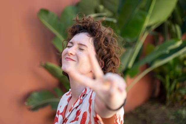 Creative Highlights Symbolbilder Smiling woman with eyes closed making peace sign model released, Symbolfoto, VRAF00533