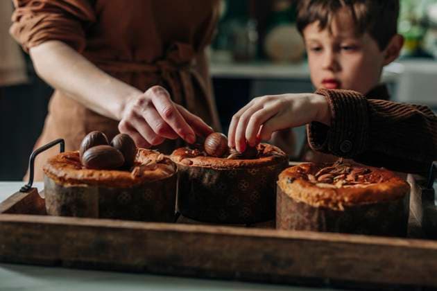 Boy and mother decorating Easter cakes with chocolate eggs in kitchen model released, Symbolfoto, VSNF01912