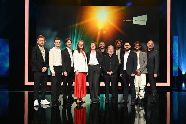 Preisträger Lukas Wunschik, Markus Ott, Nicolai Mehring, Anne Jünemann, Yana Höhnerbach, Philipp Straetker, Rainer Klausmann, Noah Böhm, Daniel Guliyev, Christopher Aoun, und Walter Demonte (Geschäftsführer des Vereins DEUTSCHER KAMERAPREIS e.V.) l-r, posieren auf der Bühne bei der Verleihung 34. Deutscher Kamerapreis