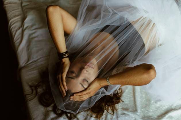 Creative Highlights Symbolbilder Young woman covering face with veil lying on bed at home model released, Symbolfoto property released, MCHF00083