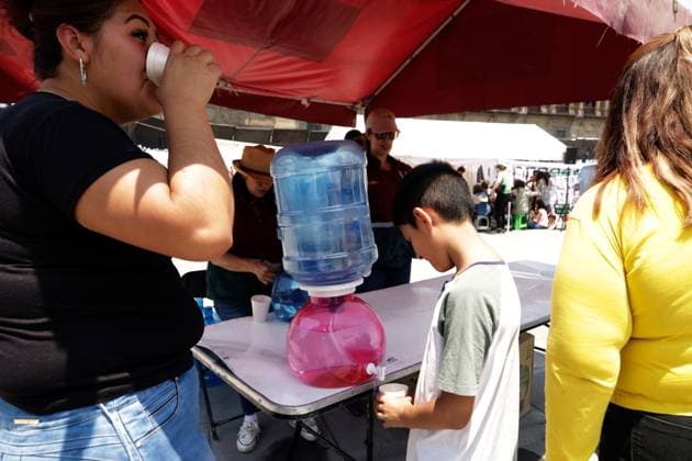High Temperatures Hits Mexico City A woman drinks water from a water dispenser to hydrate due the high temperatures hits the country, while walking in the Mexico City main square. on May 26, 2024 in Mexico City, Mexico. Mexico City CDMX Mexico Copyright: xLuisxBarronxxxEyepixxGroupx