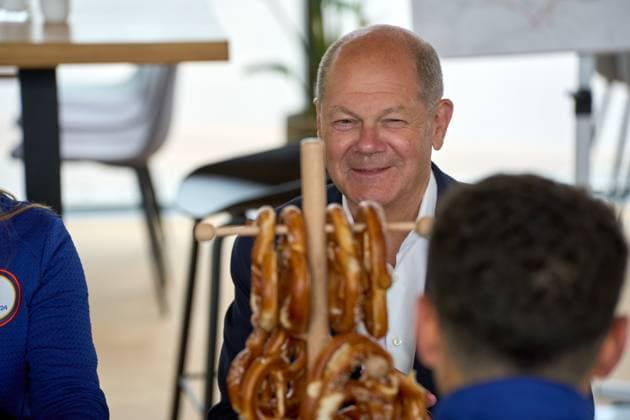 Bundeskanzler Olaf Scholz besucht den Olympiapark in München, Bayern anlässlich zur UEFA EURO 2024. Der Kanzler tauscht sich mit Helfern rund um die Fußball Europameisterschaft am Tisch mit bayerischen Brezeln aus