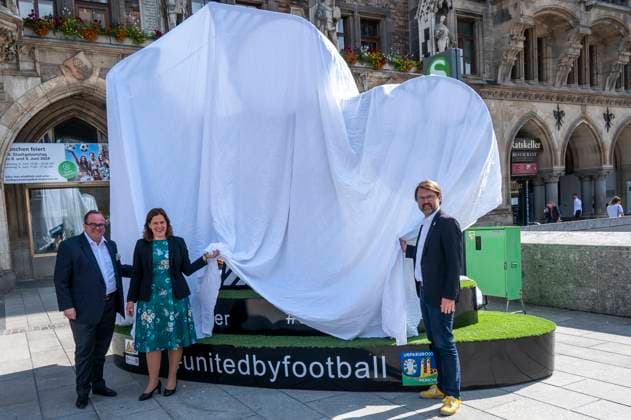 Büuergermeisterin Verena Dietl, Sportreferent Florian Kraus und Wirtschaftsreferent Clemens Baumgäaertner enthuellen auf dem Marienplatz dasMuenchner Kindl, das Teil des Spectaculars der UEFA EURO 2024 in Muenchen sein wird. Die überlebensgroße Figur soll alle Fans und Besucher*innen zum Verweilen und Zusammenkommen einladen