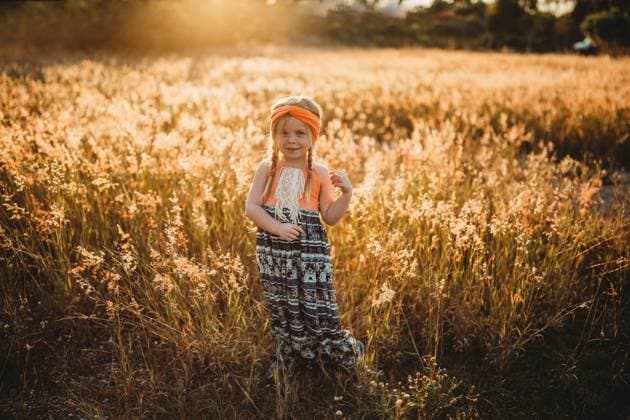 Creative Highlights Symbolbilder Young Girl in orange boho dress standing in field with golden light Fort Walton Beach, Florida, United States R_NYRF240607F4-1449912-01 ,model released, Symbolfoto