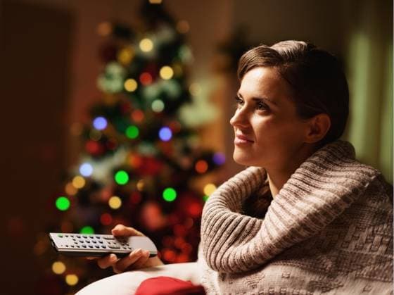 IMAGO Creative, Weihnachten, Tradition: Weihnachtsfilme sehen Happy young woman watching tv in front of christmas tree ,model released, Symbolfoto; glücklich Jung Frau zusehend Fernsehmagazin in vorne des Weihnachten Baum ,model released, Symbolfoto ING_32194_05642