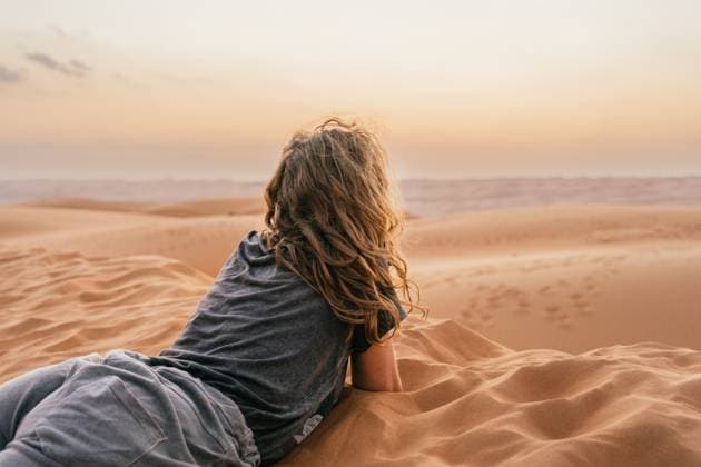 Creative Highlights Symbolbilder Anonymous woman relaxing on a sandy dune during a serene Oman trip at sunset, enjoying nature s tranquility Model Released JavierBallester_ID19646_582449_016 Copyright: xJavierxBallesterx