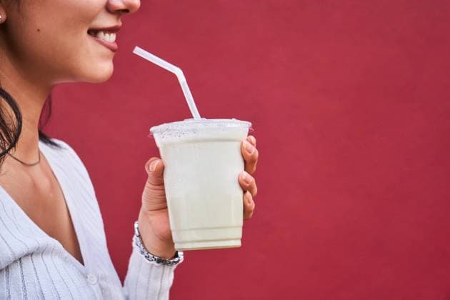 Creative Highlights Symbolbilder A cheerful young lady enjoys a refreshing beverage, holding a clear cup with a straw against a vibrant red backdrop Model Released JoseDeJesusSaldana_ID21541_632876_025 Copyright: xJosexDexJesusxSaldanax