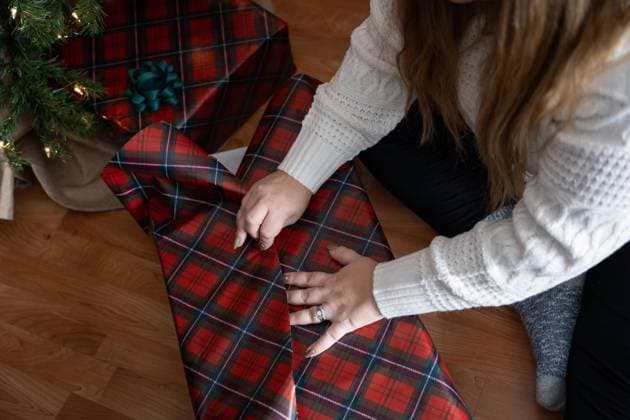 Woman s hands wrapping a Christmas present with plaid paper indoors Waunakee, Wisconsin, United States R_SUKG24061146-1453629-01 ,model released, Symbolfoto