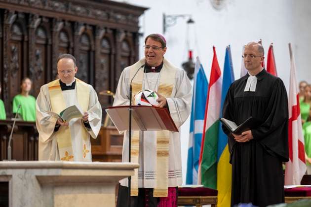 Die Deutsche Bischofskonferenz und die Evangelische Kirche in Deutschland (EKD) haben am Tag des Eroeffnungsspiels der Fussball-Europameisterschaft in Deutschland (14.06.2024) zu einem oekumenischen Gottesdienst in die Kirche St. Michael in Muenchen, der unter dem Motto United steht, eingeladen. (Foto: Den Gottesdienst leiten der Sportbeauftragte des Rates der EKD, Praeses Thorsten Latzel (re.) (Evangelische Kirche im Rheinland) und der Sportbischof der Deutschen Bischofskonferenz, Bischof Stefan Oster (Mitte) SDB (Passau)). (Siehe epd-Meldung vom 14.06.2024) EDITORIAL USE ONLY