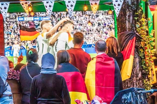 Public Viewing an der Leopoldstraße, Eröffnungsspiel Deutschland gegen Schottland, UEFA EURO 2024, München, 14. Juni 2024 Deutschland, München, 14. Juni 2024, deutsche Fußballfans beim Public Viewing an der Leopoldstraße beim Eröffnungsspiel Deutschland gegen Schottland, Endstand 5:1, hier in der ersten Halbzeit: deutsche Nationalspieler jubeln über das 2:0, Fußballfreunde mit Deutschlandfahnen bei der Live-Übertragung im Außenbereich einer Gastwirtschaft, die Fußball-Europameisterschaft dauert bis zum 14. Juli, Fußball, Sport,
