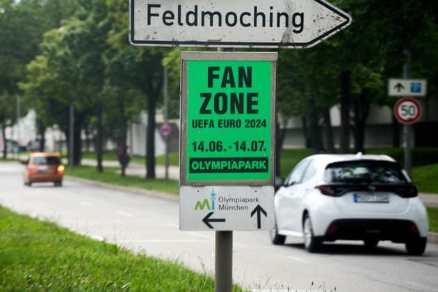 Plakat zur Fußball-Europameisterschaft zum Public Viewing in einer Fanzone, Zone für Fans im Olympiapark mit Wegweiser an einer Straße