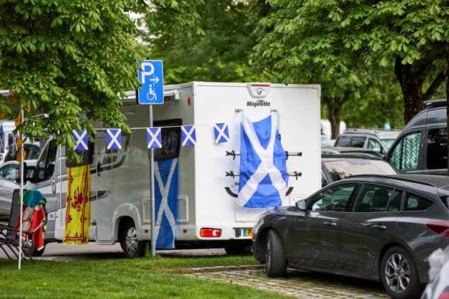 Wohnmobil auf einem Parkplatz in München, dekoriert mit schottischen Flaggen. Zuhause für Fußballfans aus Schottland während der UEFA EURO 2024