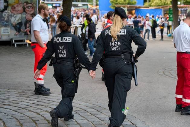 Zwei weibliche Polizistinnen der Polizei mit Waffe und Schlagstock im Einsatz bei der Fanmeile zur UEFA EURO 2024, der Fußball-Europameisterschaft, beim Spiel Deutschland gegen Schottland. Zu sehen sind Rettungssanitäter auf Bereitschaft beim Fußballspiel