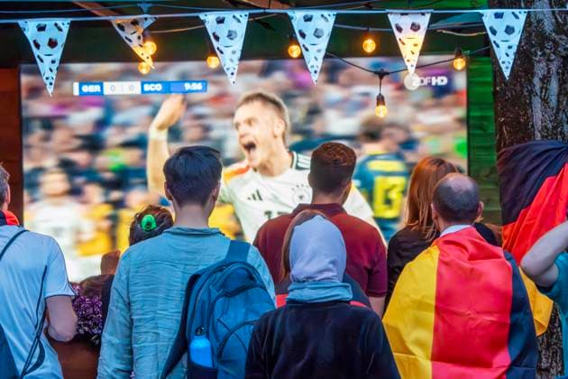 Public Viewing an der Leopoldstraße, Eröffnungsspiel Deutschland gegen Schottland, UEFA EURO 2024, München, 14. Juni 2024 Deutschland, München, 14. Juni 2024, deutsche Fußballfans beim Public Viewing an der Leopoldstraße beim Eröffnungsspiel Deutschland gegen Schottland, Endstand 5:1, hier in der ersten Halbzeit: Nationalspieler Florian Wirtz jubelt über sein 1:0 in der 10. Minute, Fußballfreunde mit Deutschlandfahnen bei der Live-Übertragung im Außenbereich einer Gastwirtschaft, die Fußball-Europameisterschaft dauert bis zum 14. Juli, Fußball, Sport,
