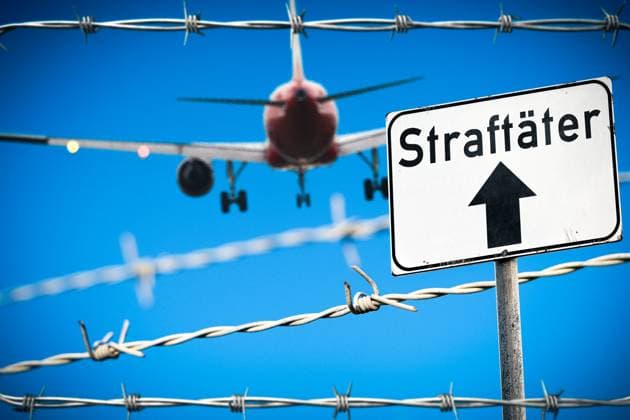 19 June 2024: Symbolic image deportation of delinquent asylum seekers and refugees. An airplane flies in the sky behind a barbed wire fence. Sign with inscription: Offenders. PHOTOMONTAGE *** Symbolbild Abschiebung von straffälligen Asylanten und Flüchtlingen. Ein Flugzeug fliegt am Himmel hinter einem Stacheldraht Zaun. Schild mit Aufschrift: Straftäter. FOTOMONTAGE