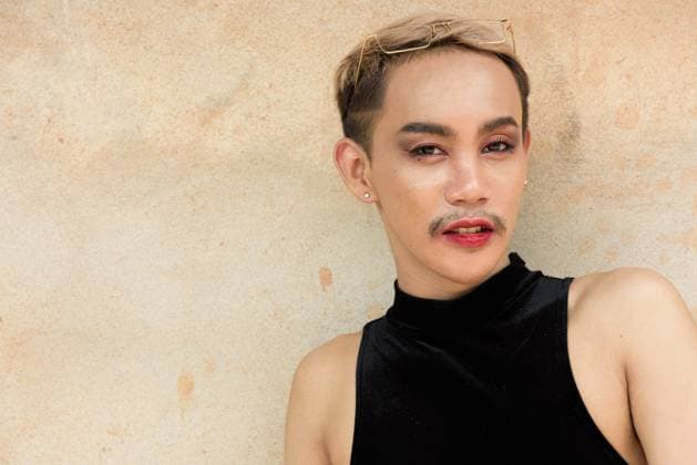 IMAGO Creative, Diversity, Teenager: LGBTQIA+ Beautiful Asian queer LGBT community supporter man with mustache wearing lipstick and jumpsuit Portrait of beautiful Asian queer LGBT community supporter man with mustache wearing lipstick and jumpsuit against beige wall background ,model released, Symbolfoto Copyright: xZoonar.com TonixRantalax 21765899 ,model released, Symbolfoto ,property released
