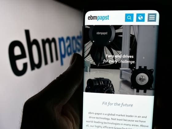 Person holding cellphone with webpage of German electric motor company EBM-Papst Gruppe. Stuttgart, Germany - 04-13-2024: Person holding cellphone with webpage of German electric motor company EBM-Papst Gruppe in front of logo. Focus on center of phone display. Copyright: xZoonar.com TimonxSchneiderx 21769429