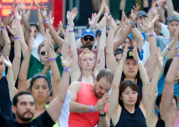 People attend a yoga class in celebration of the summer solstice at an 22nd annual all-day outdoor yoga event in Times Square in New York City on Thursday, June 20, 2024.  NYP20240620112 JohnxAngelillo