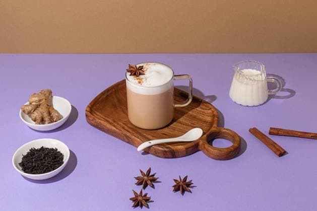 From above, Delicious chai latte with creamy foam, placed on a wooden board on a colorful backdrop Model Released OlgaVila_ID22379_653990_008 Copyright: xOlgaxVilax