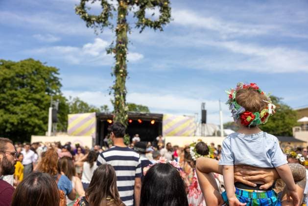 Mittsommer in Schweden Malmoe, Schweden - 21.6.2024: Menschen schmücken ihre Haare mit Blumenkränzen und feiern und tanzen um einen Midsommarstang Mittsommer im Folkets Park in Malmoe in Schweden.