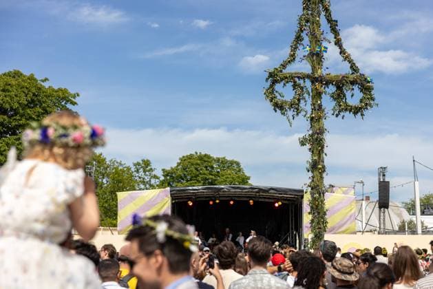 Mittsommer in Schweden Malmoe, Schweden - 21.6.2024: Menschen schmücken ihre Haare mit Blumenkränzen und feiern und tanzen um einen Midsommarstang Mittsommer im Folkets Park in Malmoe in Schweden.