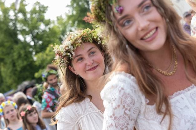 Mittsommer in Schweden Malmoe, Schweden - 21.6.2024: Menschen schmücken ihre Haare mit Blumenkränzen und feiern und tanzen um einen Midsommarstang Mittsommer im Folkets Park in Malmoe in Schweden.