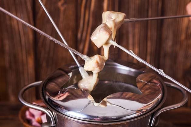 Delicious Cheese Fondue on a fork on a wooden stand. The cheese fondue ,model released, Symbolfoto; Köstlich Käse Fondue am einer Gabel am einer hölzern Ständer der Käse fondue ,model released, Symbolfoto ING_33849_15158