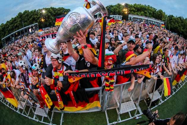 EM 2024: Public viewing in Berlin Deutschland gegen Oesterreich, Fan Zone vor dem Brandenburger Tor. Die Fans feuern ausgelassen die Mannschaft an und halten einen Pokal in die Höhe. Berlin Berlin Deutschland