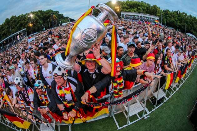 EM 2024: Public viewing in Berlin Deutschland gegen Oesterreich, Fan Zone vor dem Brandenburger Tor. Die Fans feuern ausgelassen die Mannschaft an und halten einen Pokal in die Höhe. Berlin Berlin Deutschland