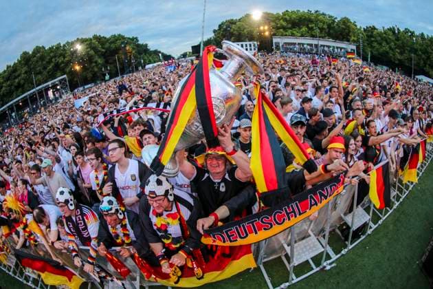 EM 2024: Public viewing in Berlin Deutschland gegen Oesterreich, Fan Zone vor dem Brandenburger Tor. Die Fans feuern ausgelassen die Mannschaft an und halten einen Pokal in die Höhe. Berlin Berlin Deutschland