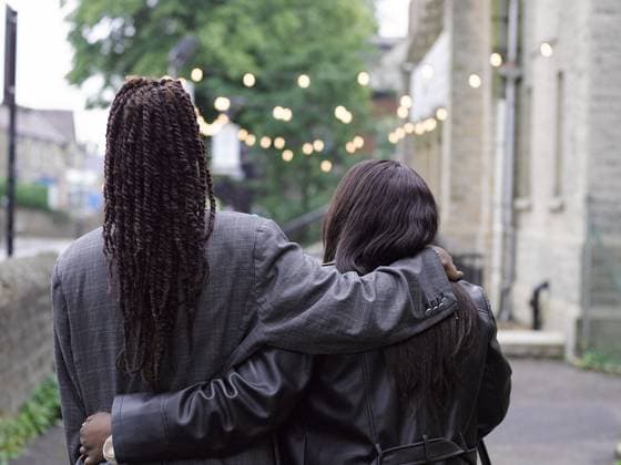 Rear view of friends embracing outdoors model released Copyright: xCulturaxCreativex