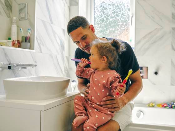 Father helping daughter brushing teeth in bathroom model released Copyright: xCulturaxCreativex