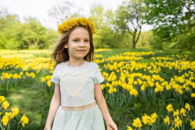 Creative Highlights Symbolbilder Smiling girl wearing dandelion wreath and standing in daffodil field model released, Symbolfoto, ASVF00022