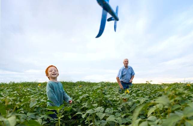 Creative Highlights Symbolbilder Happy boy playing with grandfather in field model released, Symbolfoto, MBLF00426
