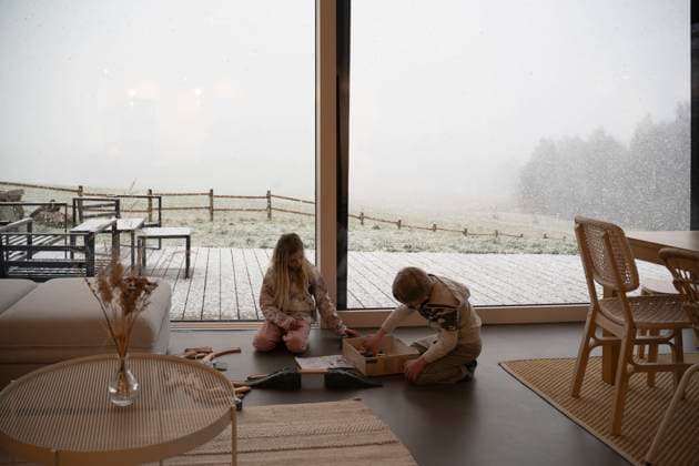 Siblings playing by large window at home in winter model released, Symbolfoto property released, NJAF01070