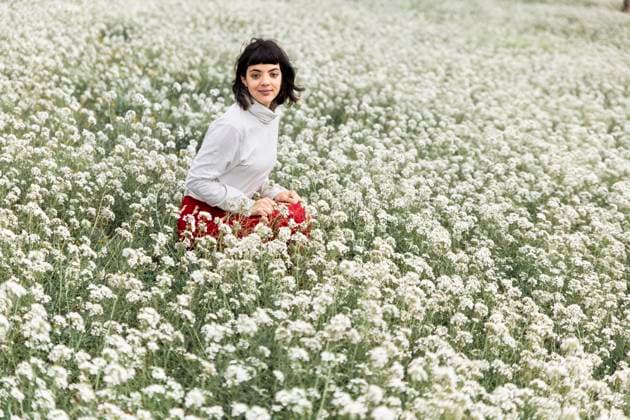 Creative Highlights Symbolbilder Young beautiful woman squatting amidst white flowers at field model released, Symbolfoto, PCLF01352