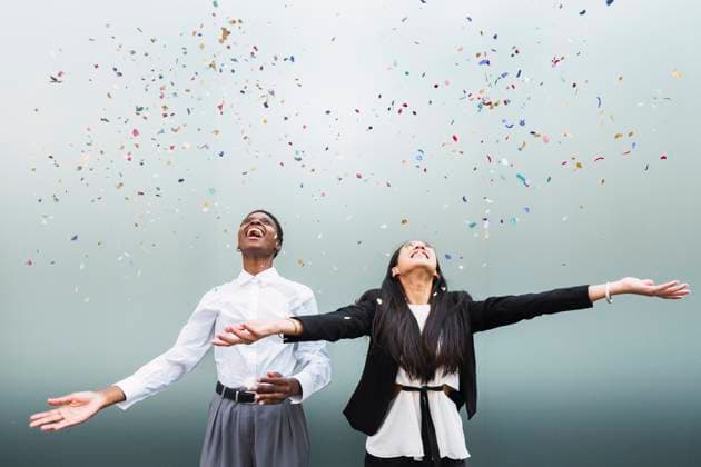 Creative Highlights Symbolbilder Happy multiracial colleagues with arms outstretched standing under falling confetti model released, Symbolfoto, PNAF06254