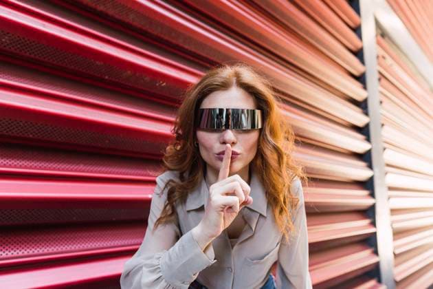 Creative Highlights Symbolbilder Woman wearing smart glasses and holding finger over lips near corrugated iron model released, Symbolfoto, PNAF06339